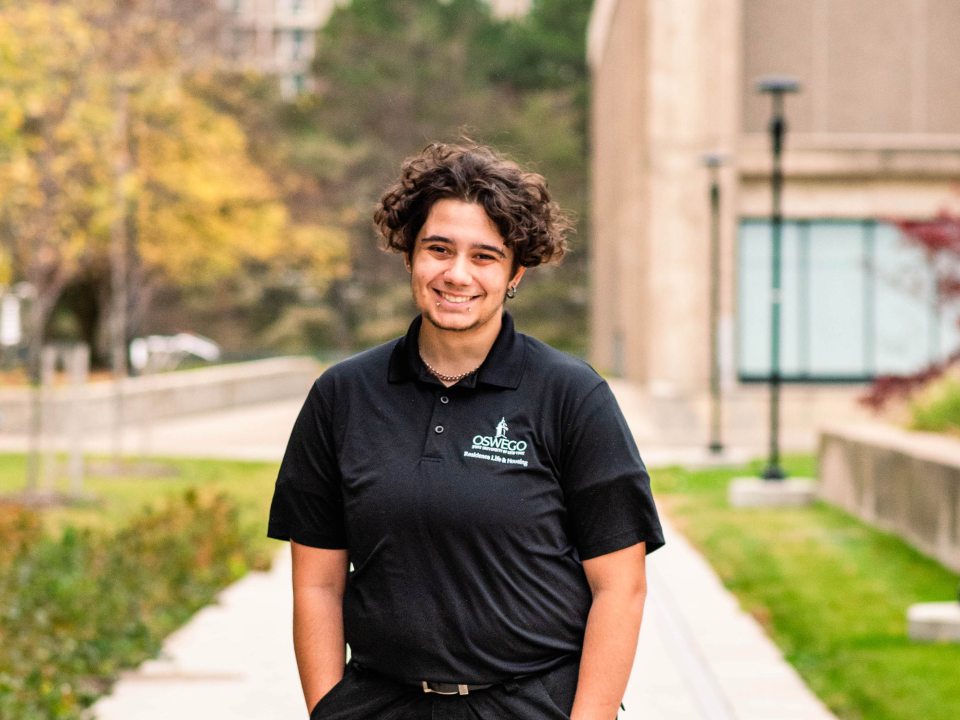 Student standing wearing a black RA polo.