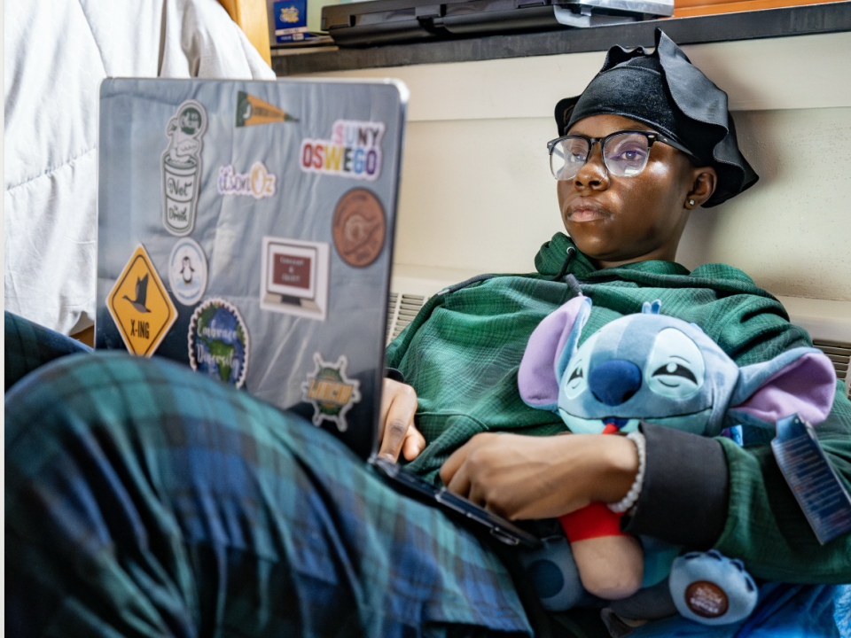 Student sitting on their lazy bag with a laptop. 