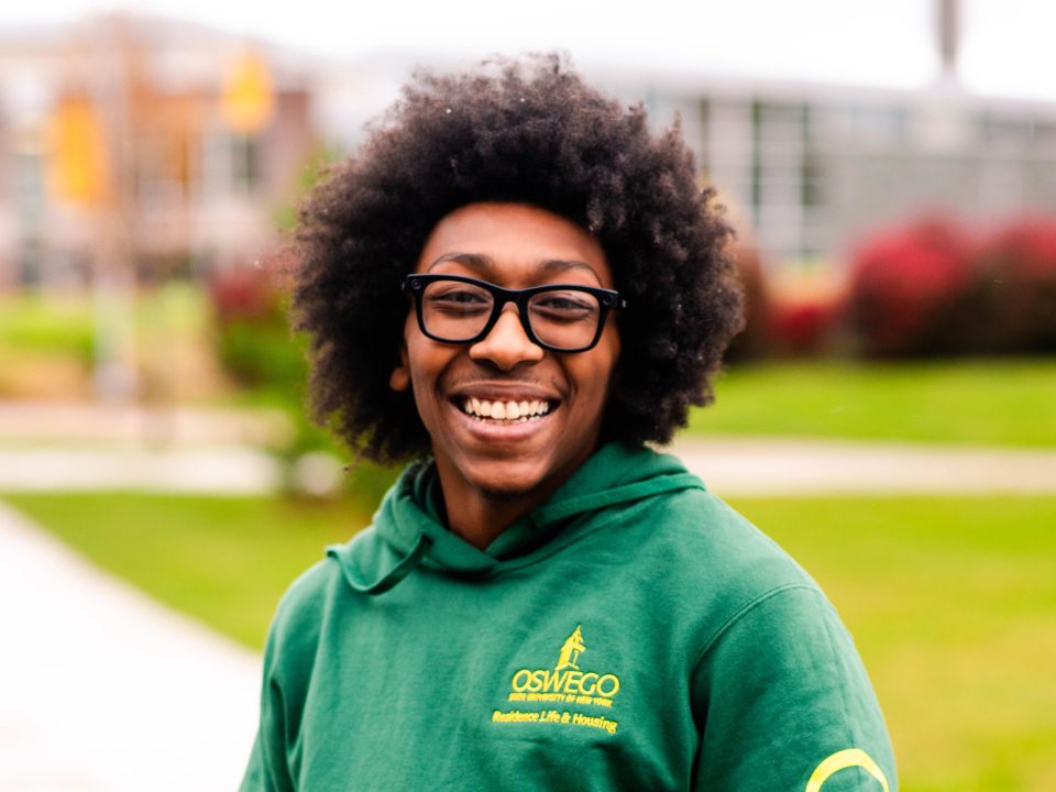 RA wearing a their RA hoodie and smiling 