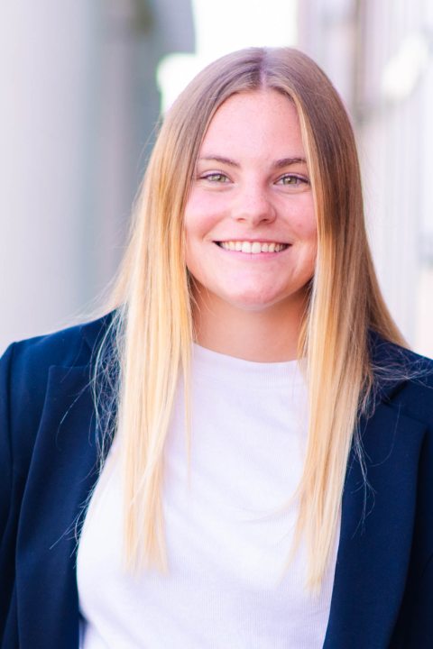 Head shot of Taylor next to a brick wall.