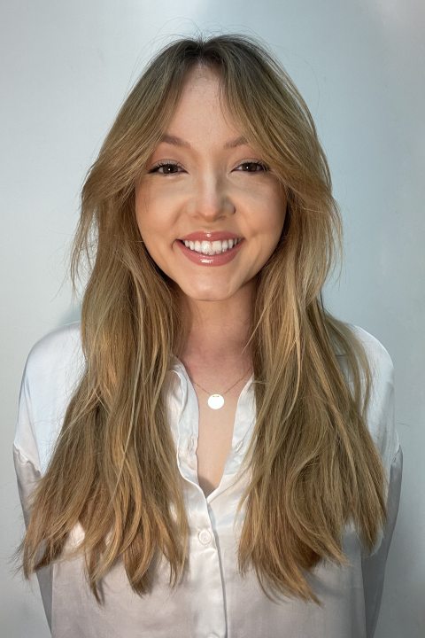 Head shot of Andjela in front of a white wall. 