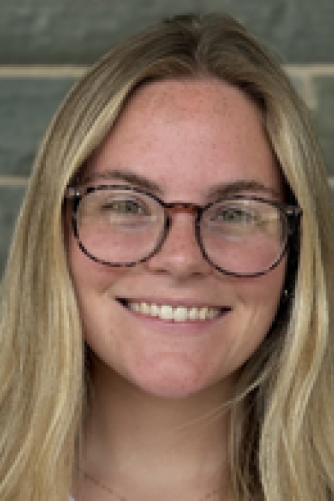 Taylor Ladue smiling and wearing glasses.