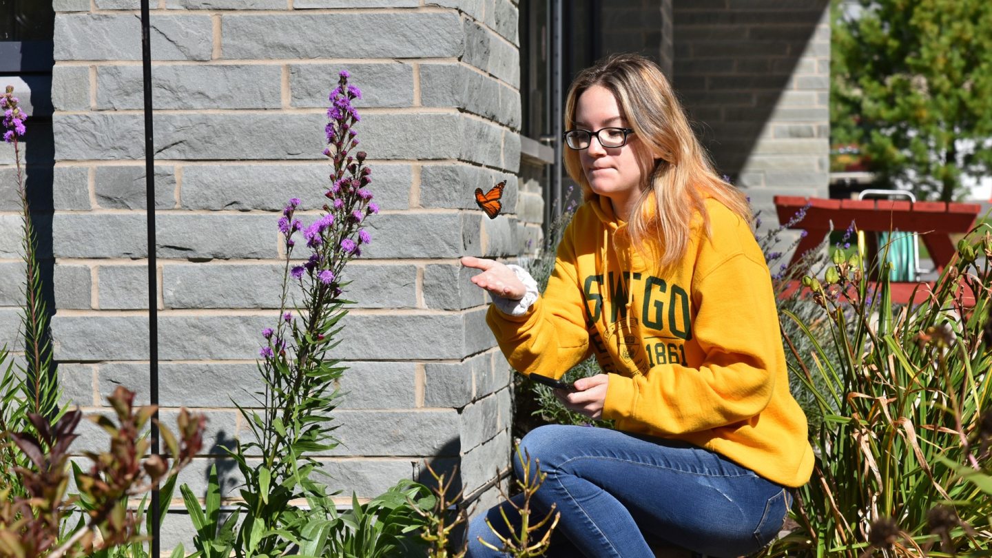 Oswego student with monarch butterfly