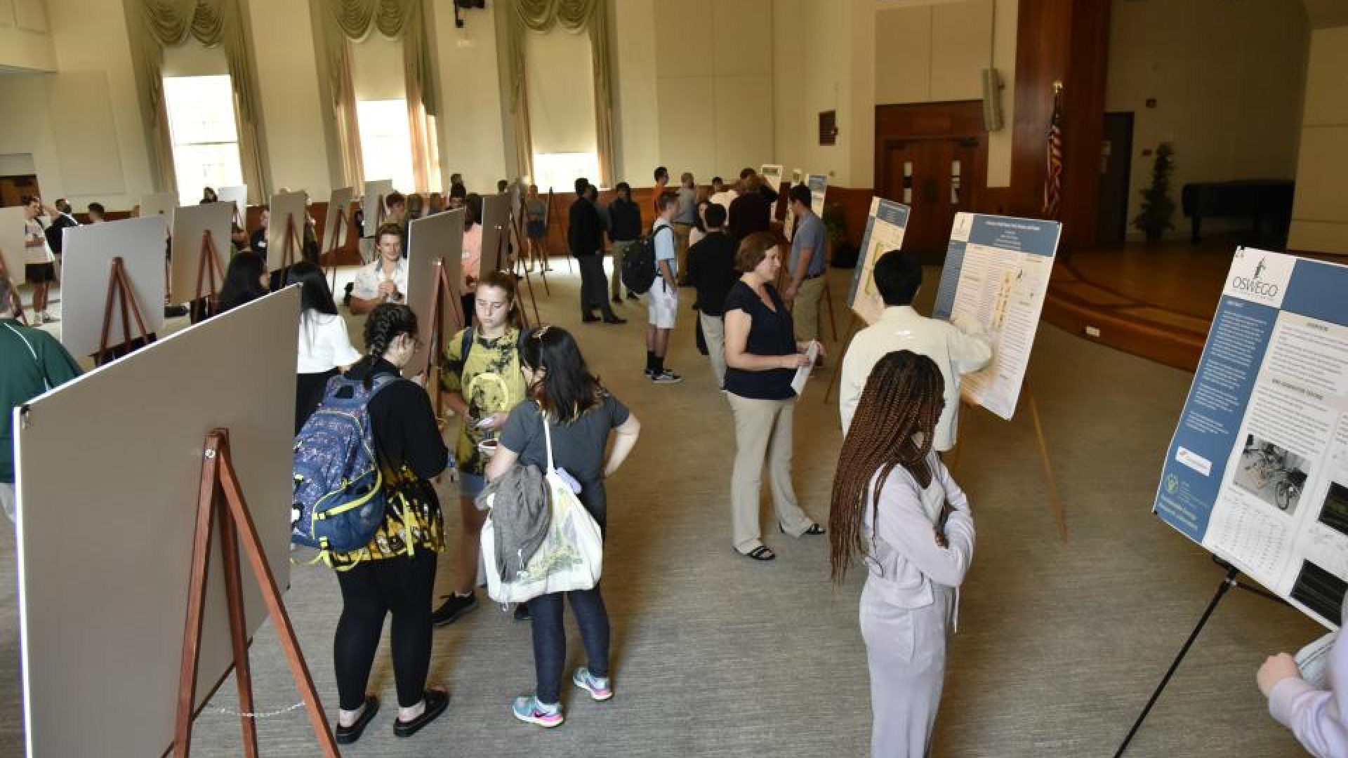 People looking at poster projects in a large open space
