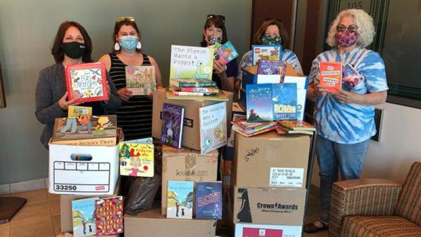 Volunteers showing off books collected for the Bookmobile