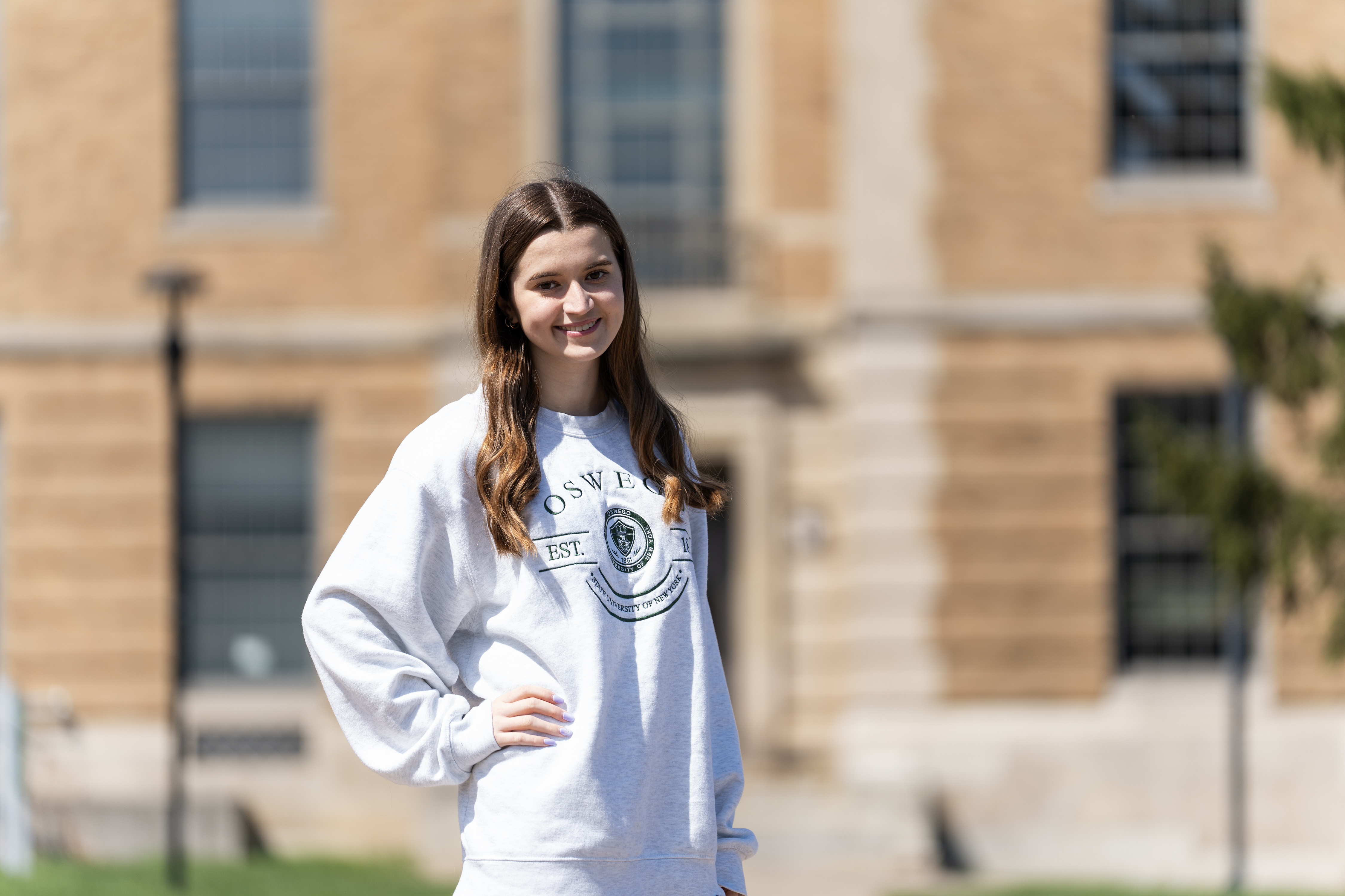 SUNY Oswego Happy Student in front of Rick Hall 