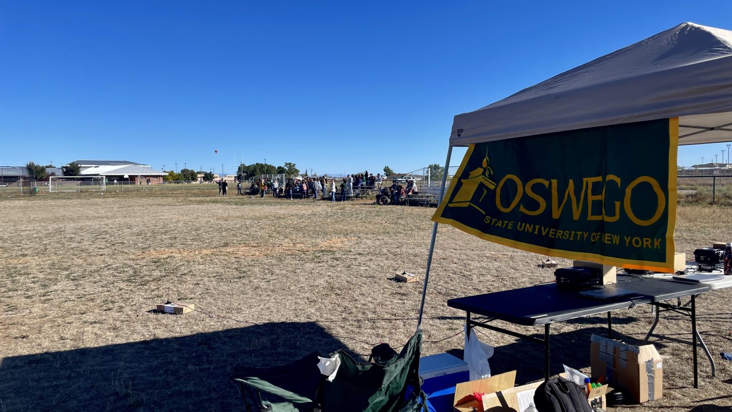 an outdoor tent with an Oswego banner