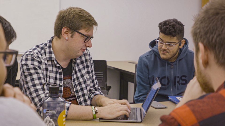 Five ECE students work at a roundtable