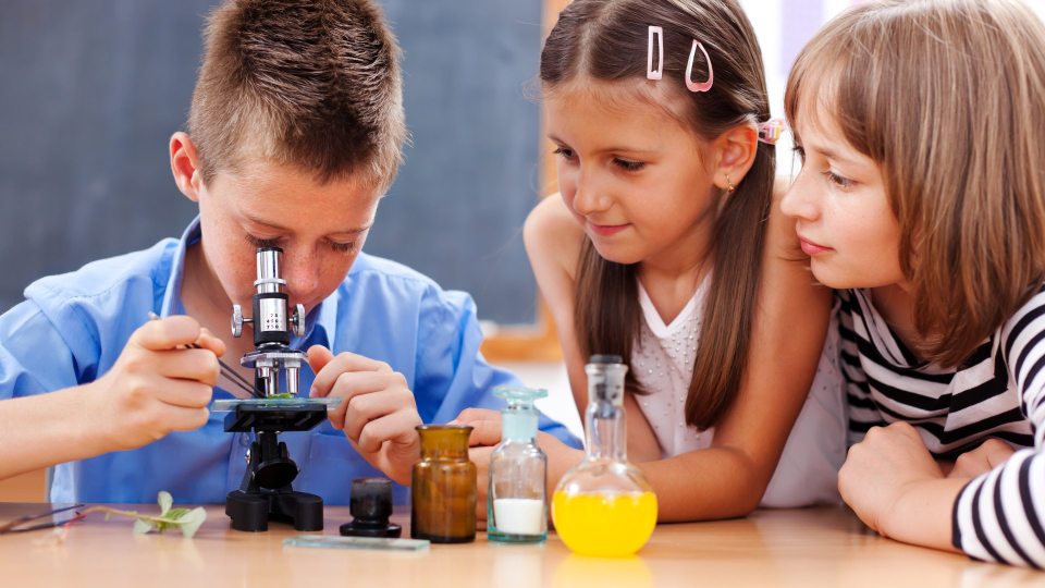 Three children around a microscope
