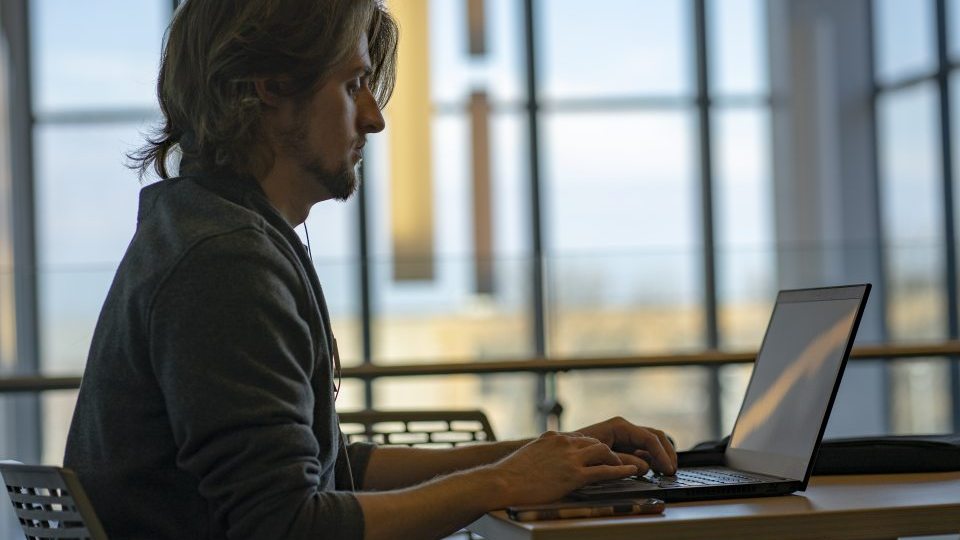 A male student working on a laptop