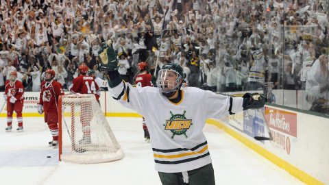 A member of the Laker hockey team yells and raises his arm in celebration on the ice