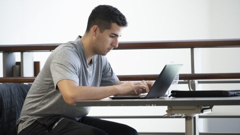 male student working on laptop