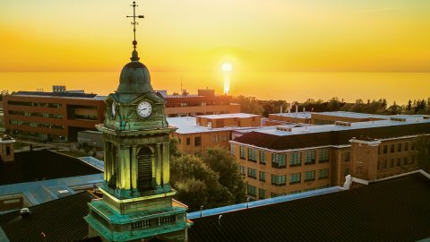 Sheldon Hall’s cupola framed by a golden sunset over the lake.