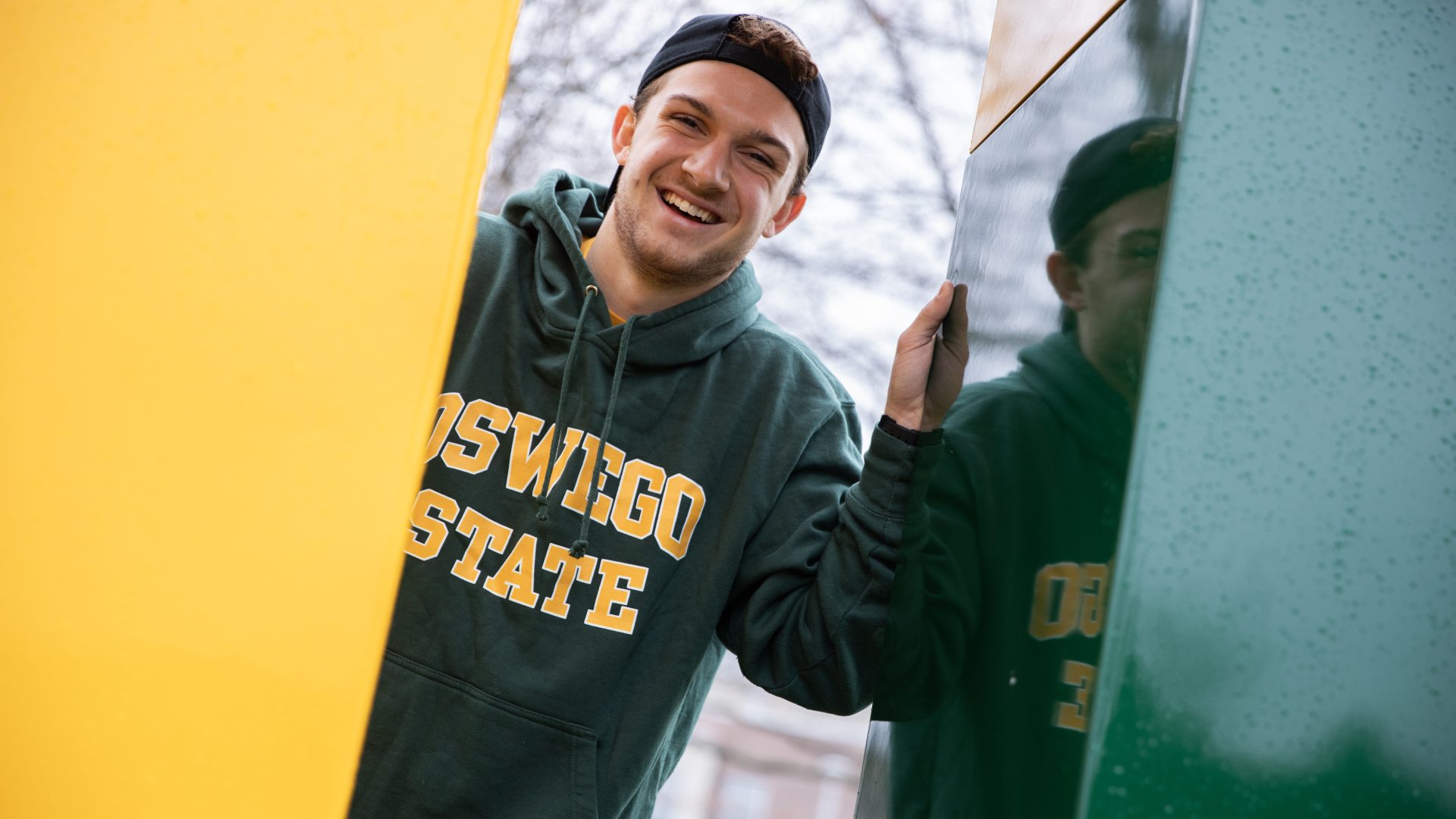 Student Smiling wearign SUNY Oswego Sweatshirt
