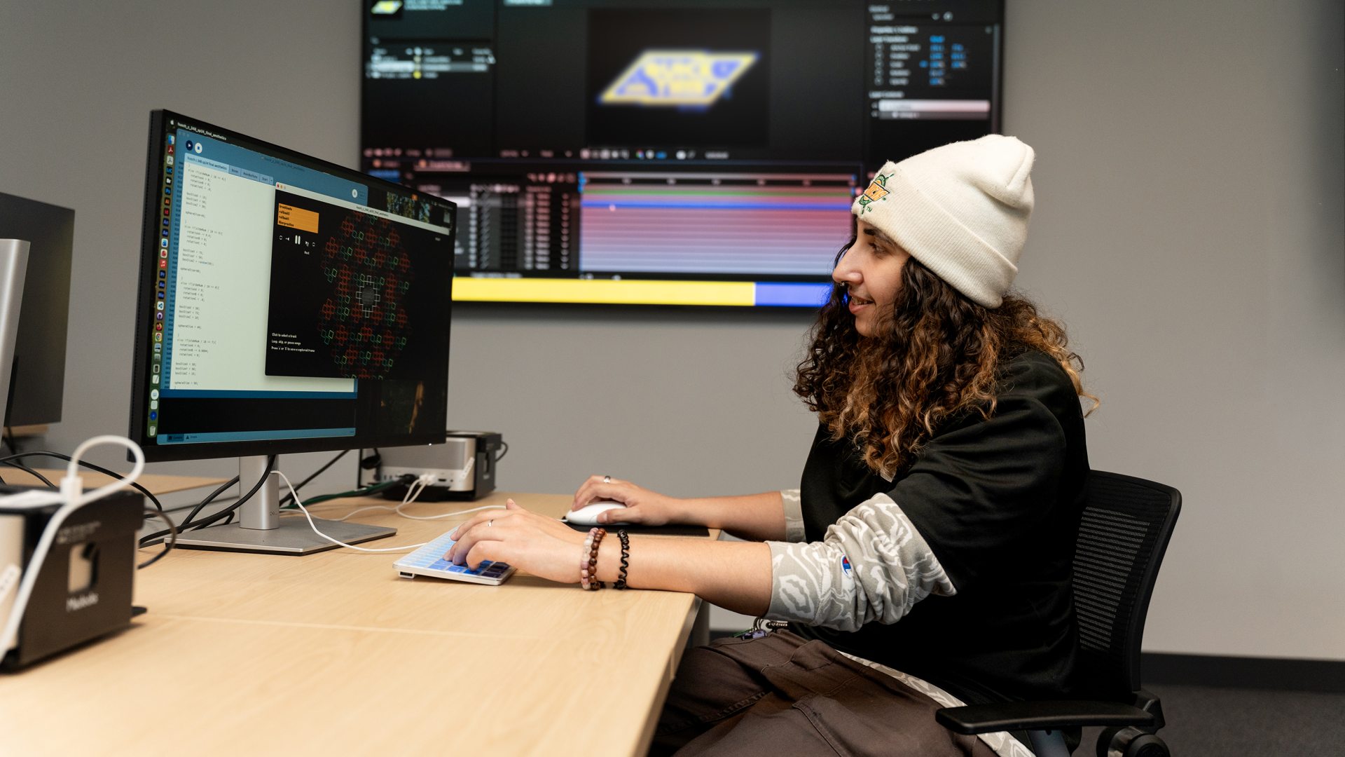 Interaction design student working at a computer with multiple monitors.