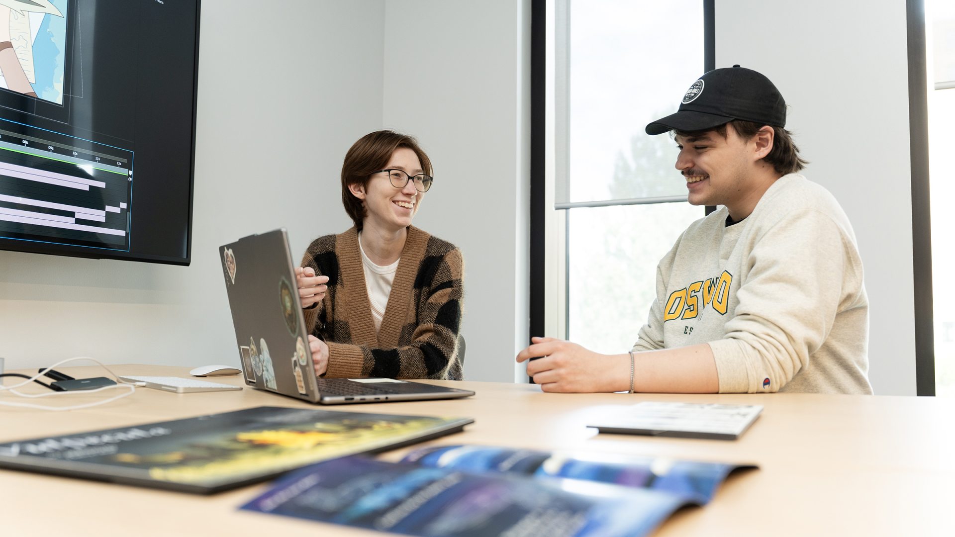 Two students work together on a laptop.