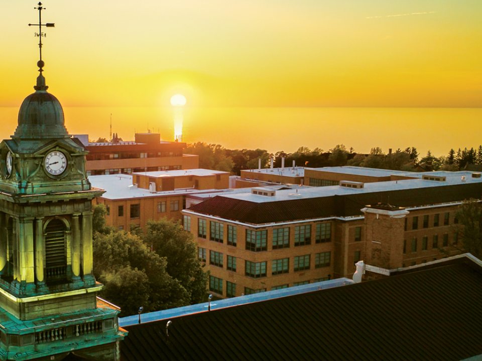 Sheldon Hall’s cupola framed by a golden sunset over the lake.