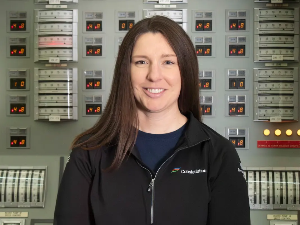Riley Hook standing in front of control panels at Nine Mile Point Nuclear Station.