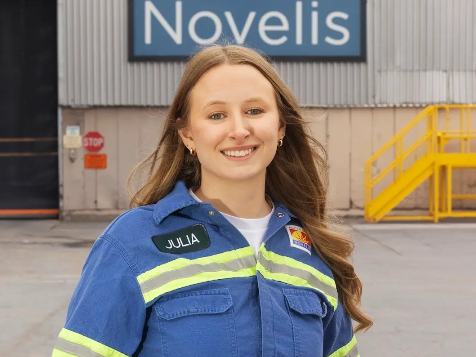 Julia Clark standing outside Novelis in safety workwear.