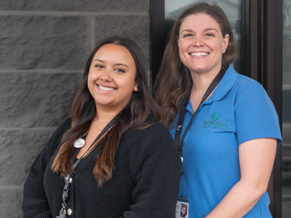 Two women standing together, smiling