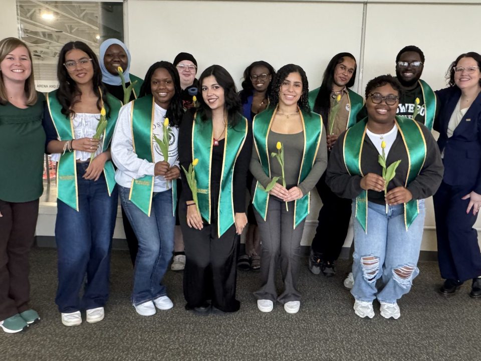 A group of students wearing green stoles representing CSTEP