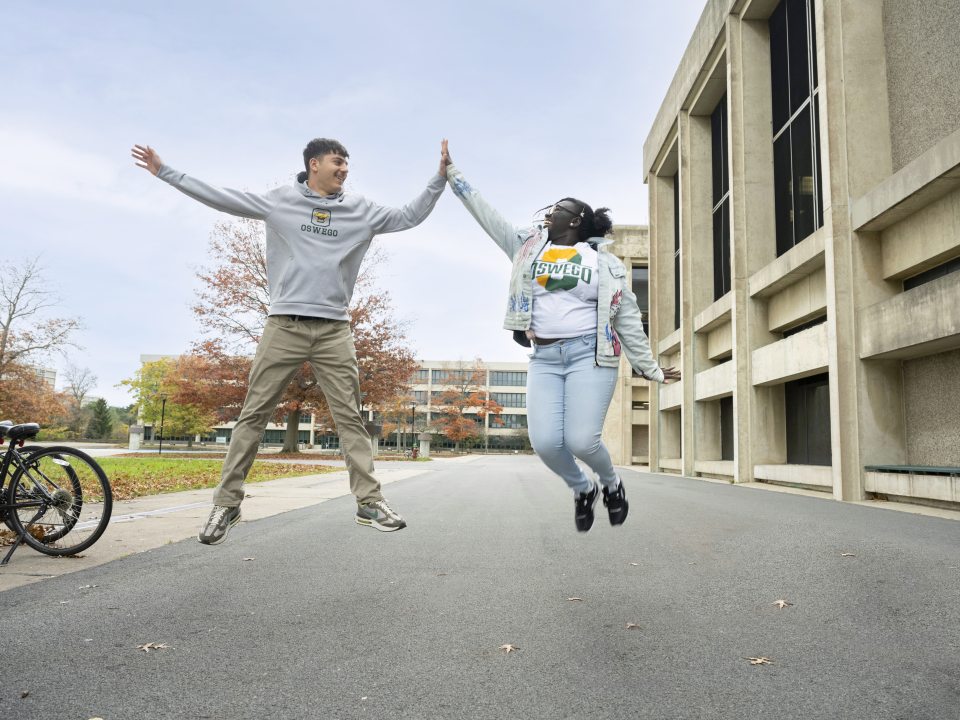 two students excited jumping up for a high five