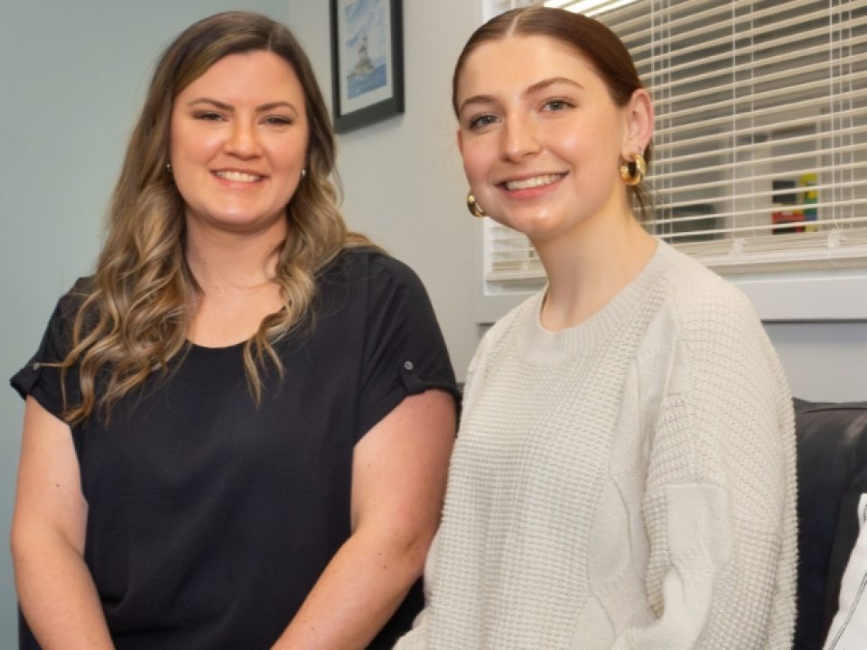 Alexandra Fitzpatrick (left) and Natalie Glosek (right) seated on a couch in the Operation Oswego County offices.