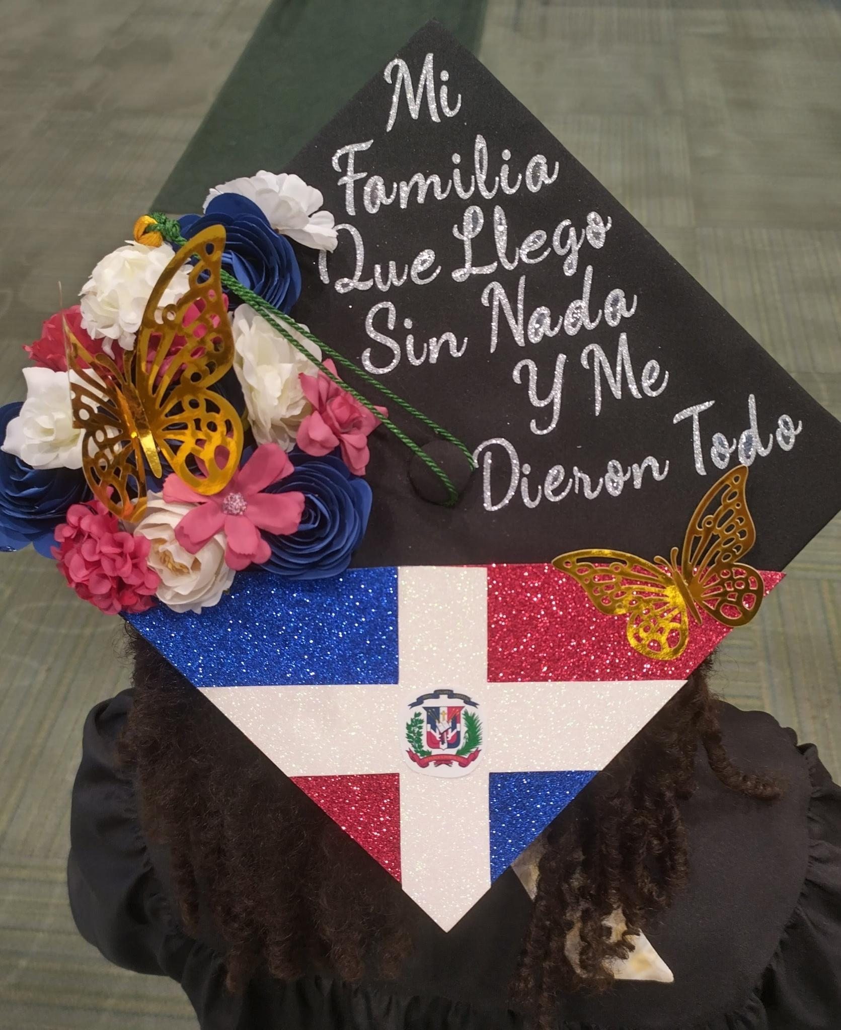 Graduation cap with the Dominican flag states in Spanish "My family that arrived with nothing and gave me everything"
