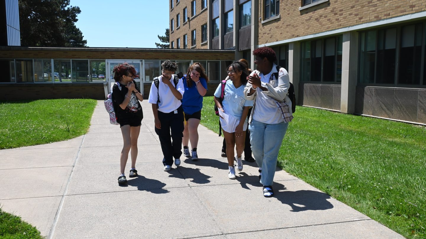Students smiling and laughing on the way to an Orientation Session