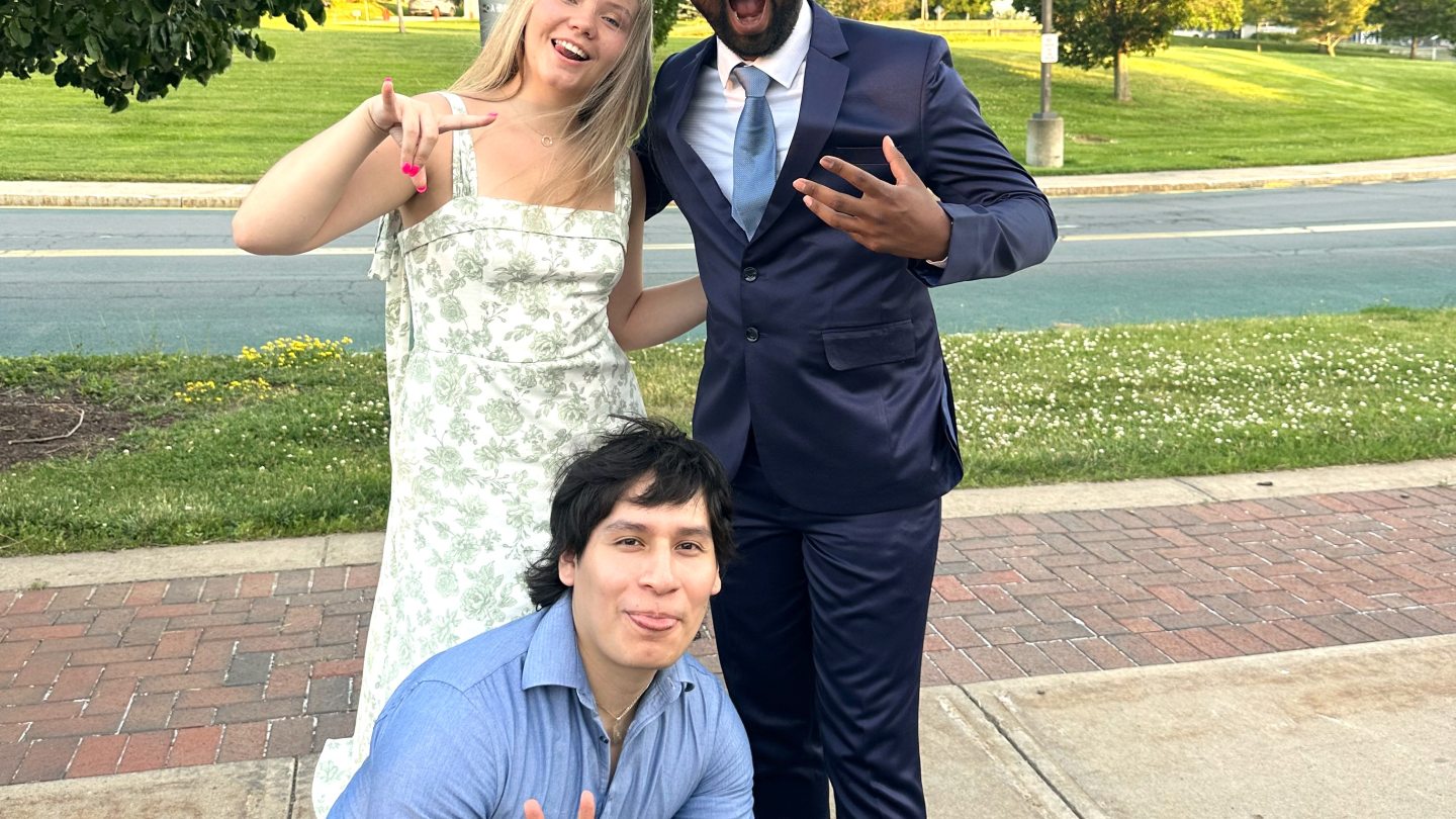 Three Orientation Leaders dressed up, making goofy faces into the camera