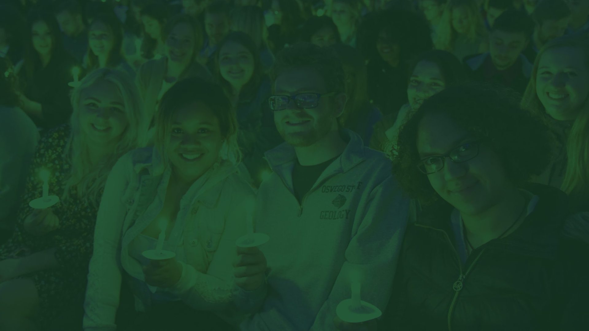 students holding candles with a green overlay