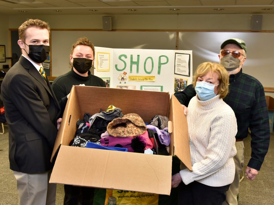 Sally and John Stroka, both alumni from the class of 1966, dropped off a large collection of items for the Winter Warm Up event that SHOP (Students Helping Oz Peers) hosted in 133 Marano Campus Center Feb. 15 through 17. At left accepting the donations is Helena Buttons, SHOP coordinator, and Jake Czaplicki, an intern with the Dean of Students Office.