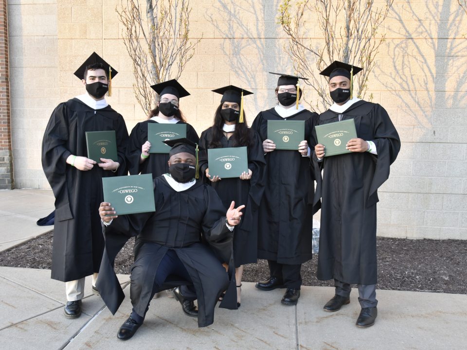 Commencement graduation ceremony photo of a group of students with their degree