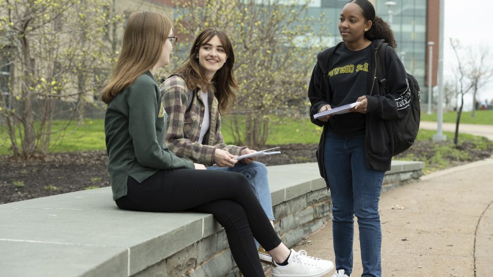 Three students sitting outside