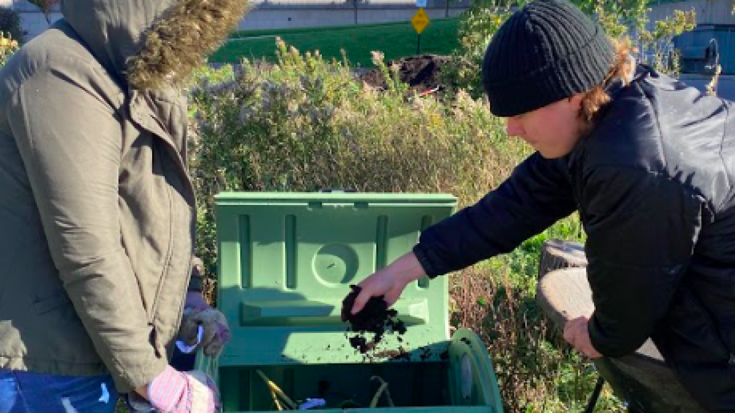 Two students in the garden, composting