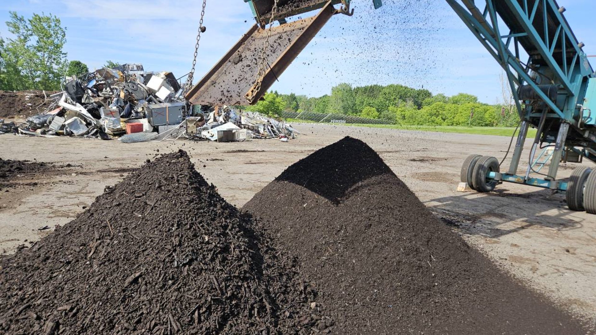 Piles of compost at Bristol Hill composting facility being dropped by a conveyor