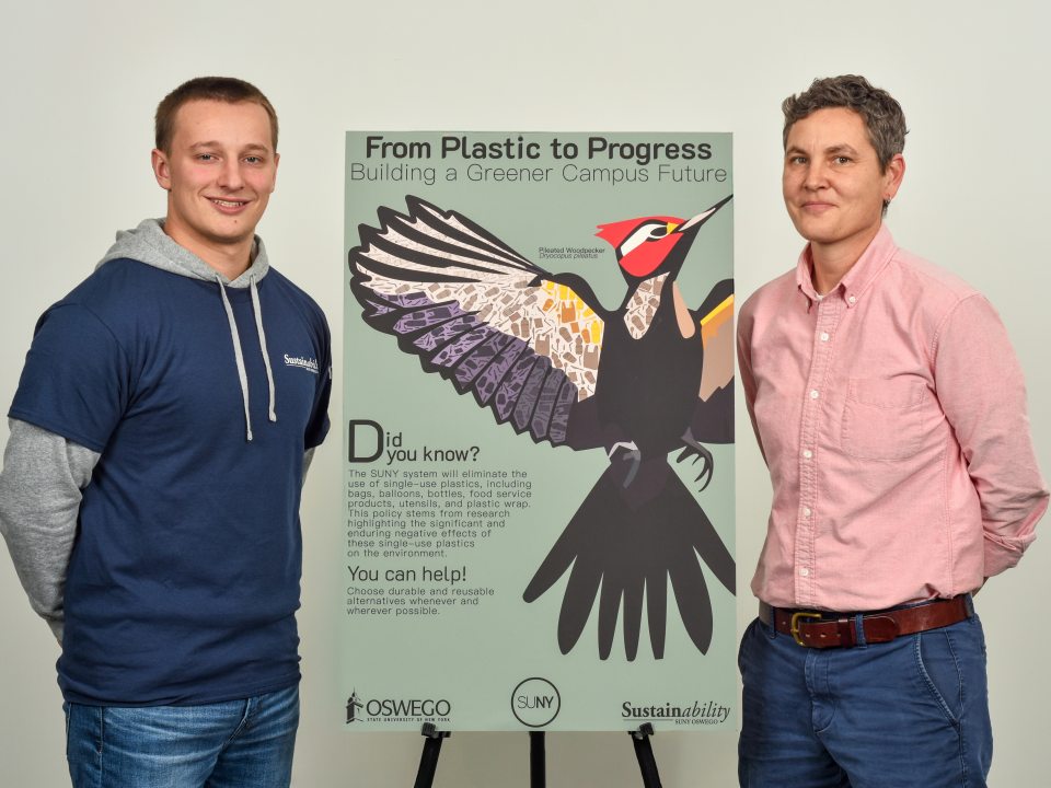 Intern Zandyr Meakin and Director Kate Spector standing with a poster pertaining to single use plastic phase out