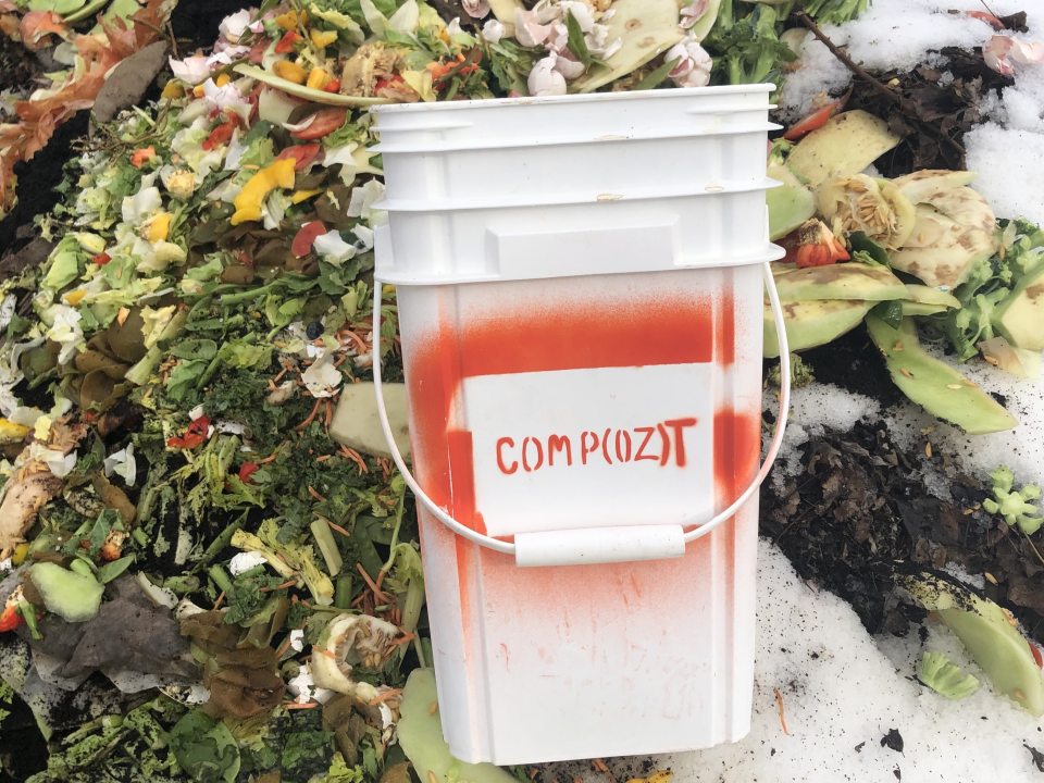 Composting bucket laying on pile of food scraps