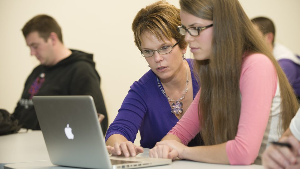 Amy bidwell working with student