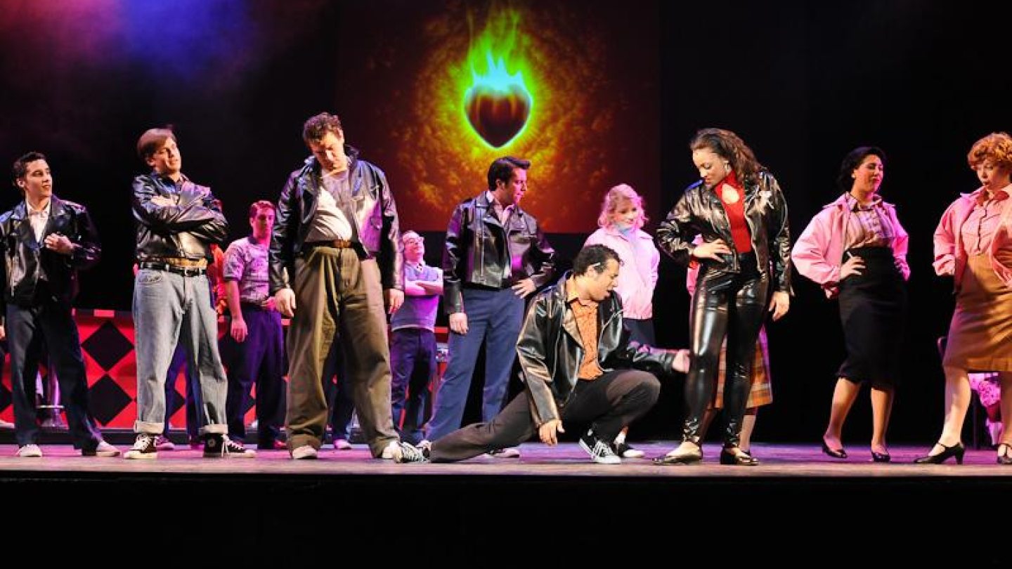 image of the cast of Grease acting on stage