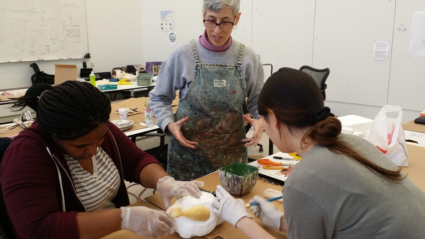 Three people working on a properties mold