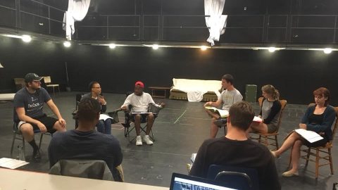 group of students sitting in chairs in a circle discussing something
