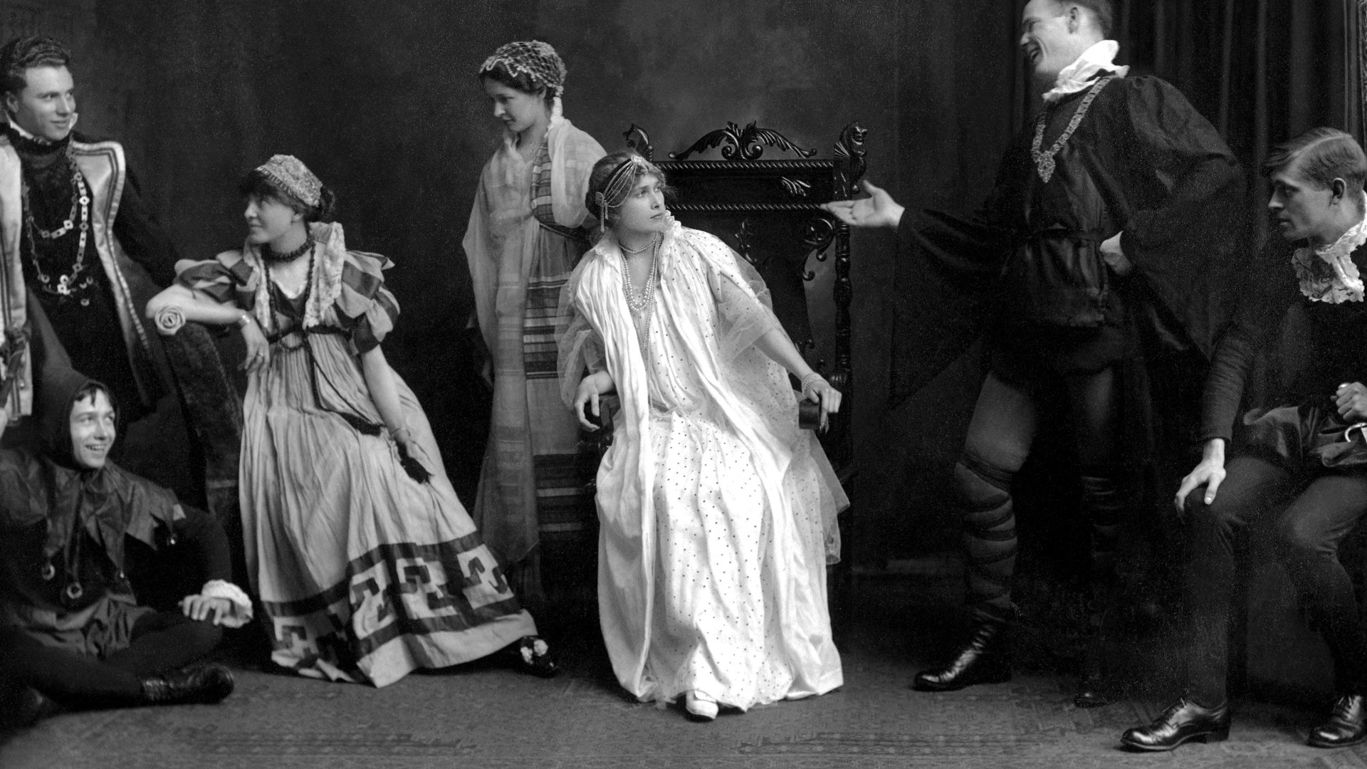 black and white image of a group of actors on stage acting a scene