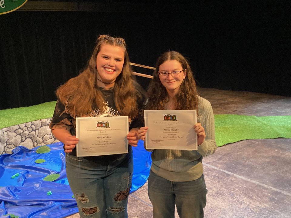 Two students holding up certificates