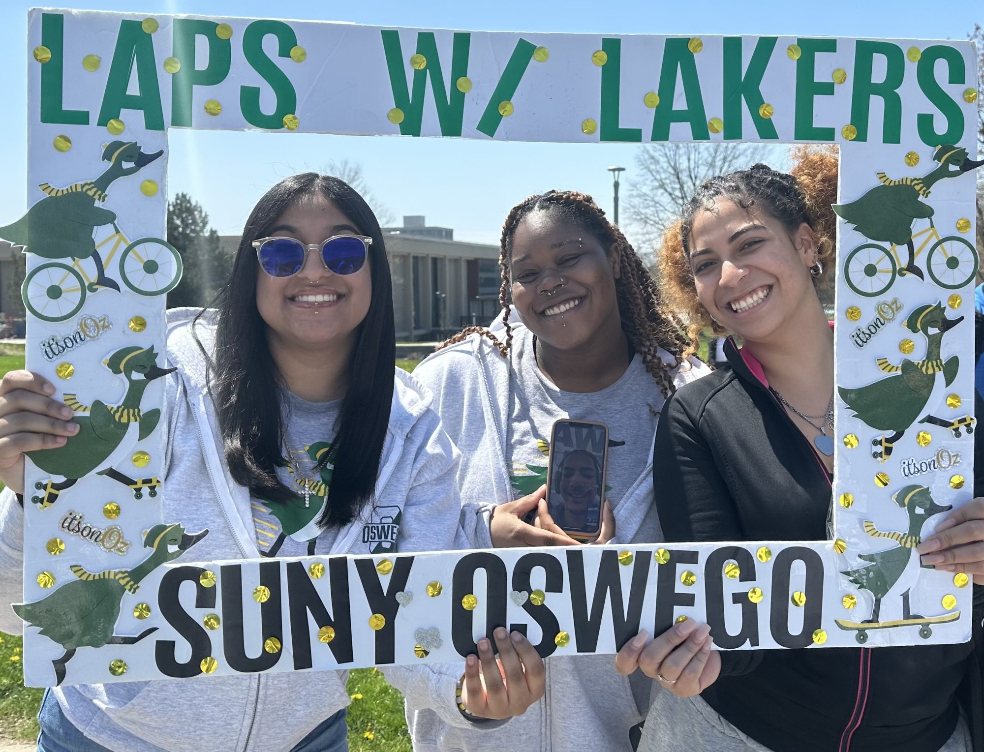 three students holding Laps with Lakers photo cut out