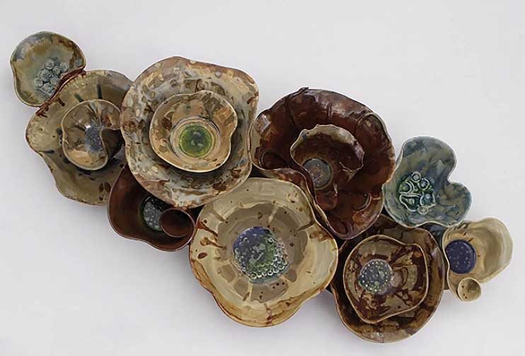 This is a wall piece made up of throw bowls (all different sizes and shapes) that were rendered to create a more organic looking feel to them. This piece was a very experimental piece, so that glazes used was applied in a very painterly way. I also used the element of glass which fused in the bottom of my piece. The glass ended up creating great contrast throughout my piece.