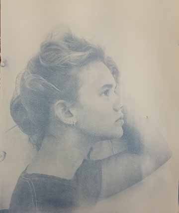 A woman looking to the right, holding her hair up.