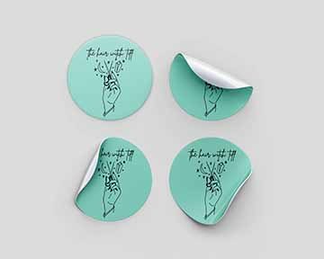 turquoise blue stickers that feature The Hair Witch Tiff logo that has a hand holding a pair of shears, surrounded by stars, a moon + a crystal