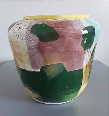 A large cylindrical vase that is wide at the top and narrows to the bottom. The glazing is an abstract expression of Attention Deficit Disorder reflecting the typical struggle of indecision.