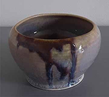 A small bowl whose glazing application resulted in a drip effect down the side of the vessel.